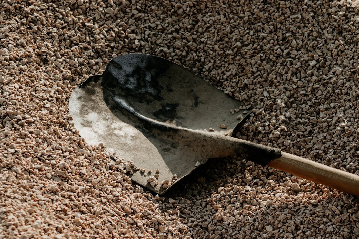 Shovel standing in a heap of crushed stone aggregate