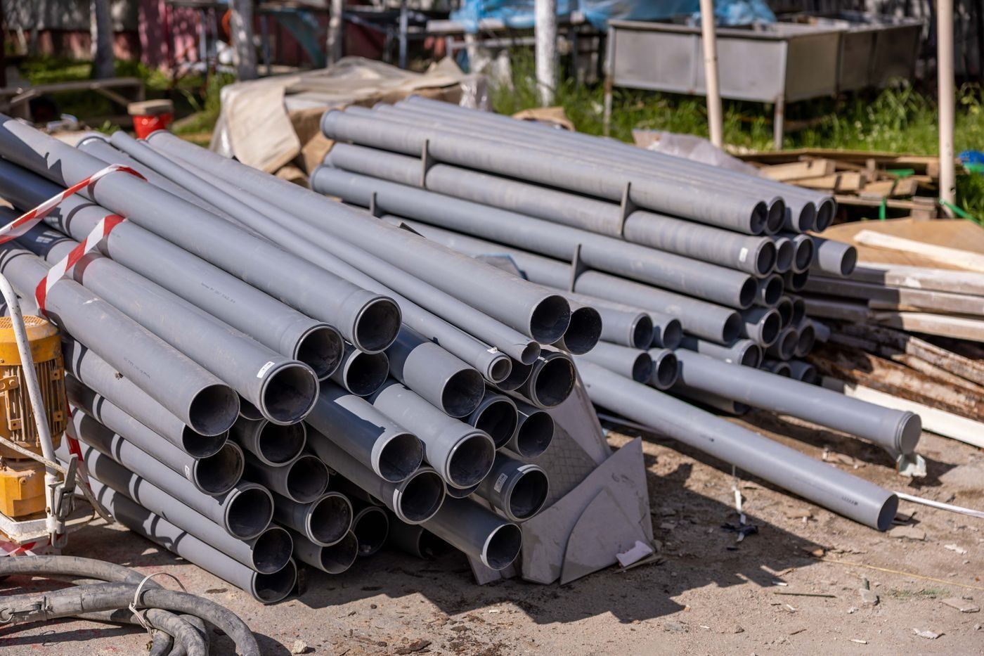 Stacks of grey uPVC drainage pipe waiting to be installed on site